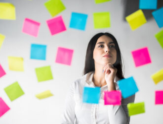 Mujer escribiendo sus metas en una agenda, enfocada en la planificación para el nuevo año.