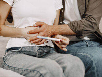 Pareja sostiene prueba de embarazo, esperanza después de infertilidad