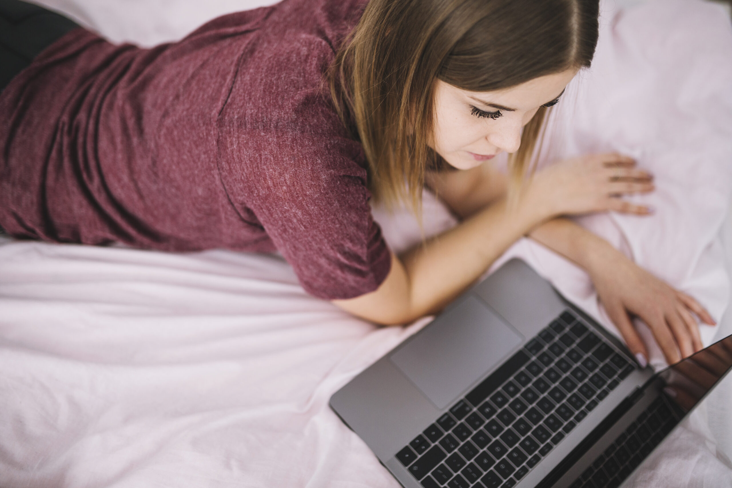 Mujer joven usando una computadora portátil desde casa, imagen representativa de los retos digitales que enfrentan adolescentes y familias en Guatemala