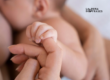 Primer plano de la mano de un bebé sosteniendo el dedo de su madre durante un momento de conexión